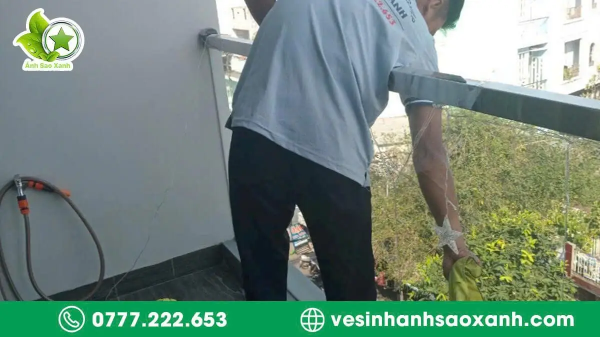 Nhân viên Ánh Sao Xanh đang lau kính nhà ở TPHCM tại khu vực ban công chung cư