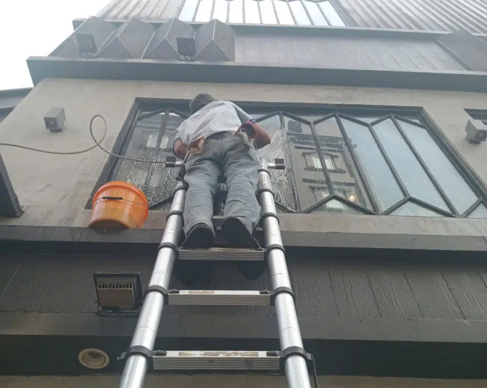 Thợ lau kính tòa nhà tại TPHCM bằng thang nhôm