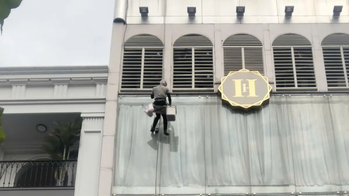 Thợ lau kính tòa nhà cao tầng tại TPHCM bằng phương pháp đu dây