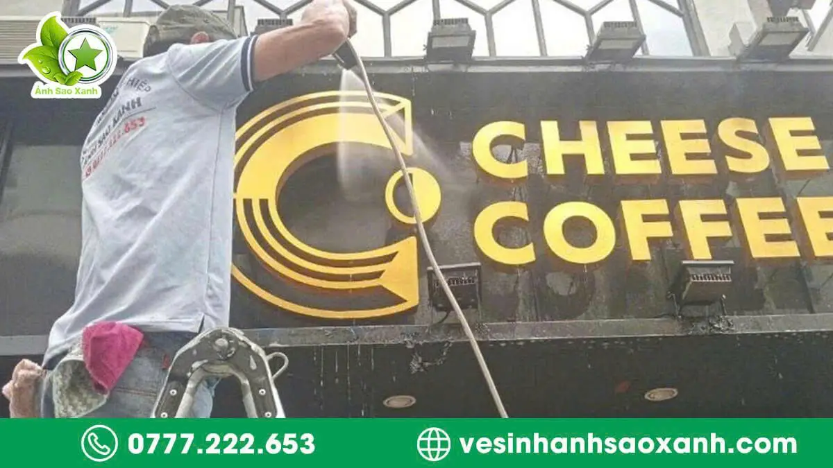 Kỹ thuật viên Ánh Sao Xanh vệ sinh chữ nổi inox và decal mặt tiền quán cà phê tại TPHCM bằng thiết bị chuyên dụng.