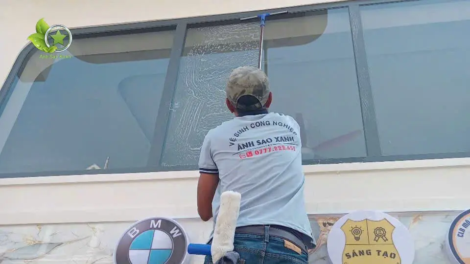 Nhân viên lau kính mặt dựng bên trong trung tâm thương mại tại TPHCM