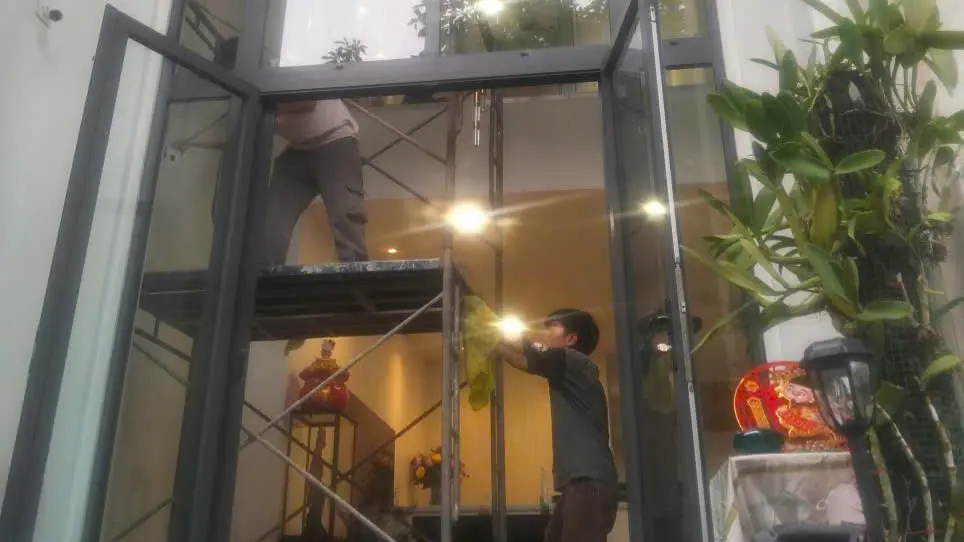 Nhân viên lau kính nhà ở tại TPHCM bằng giàn giáo