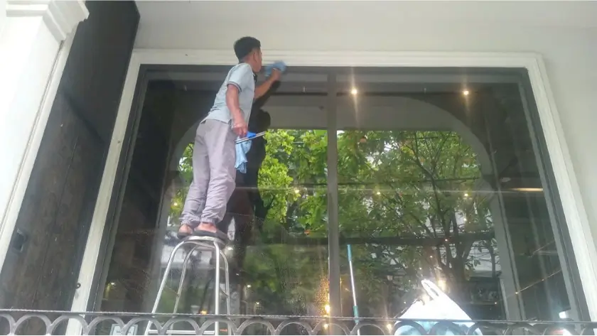 Nhân viên Ánh Sao Xanh lau kính quán cafe tại Bình Thạnh, TPHCM